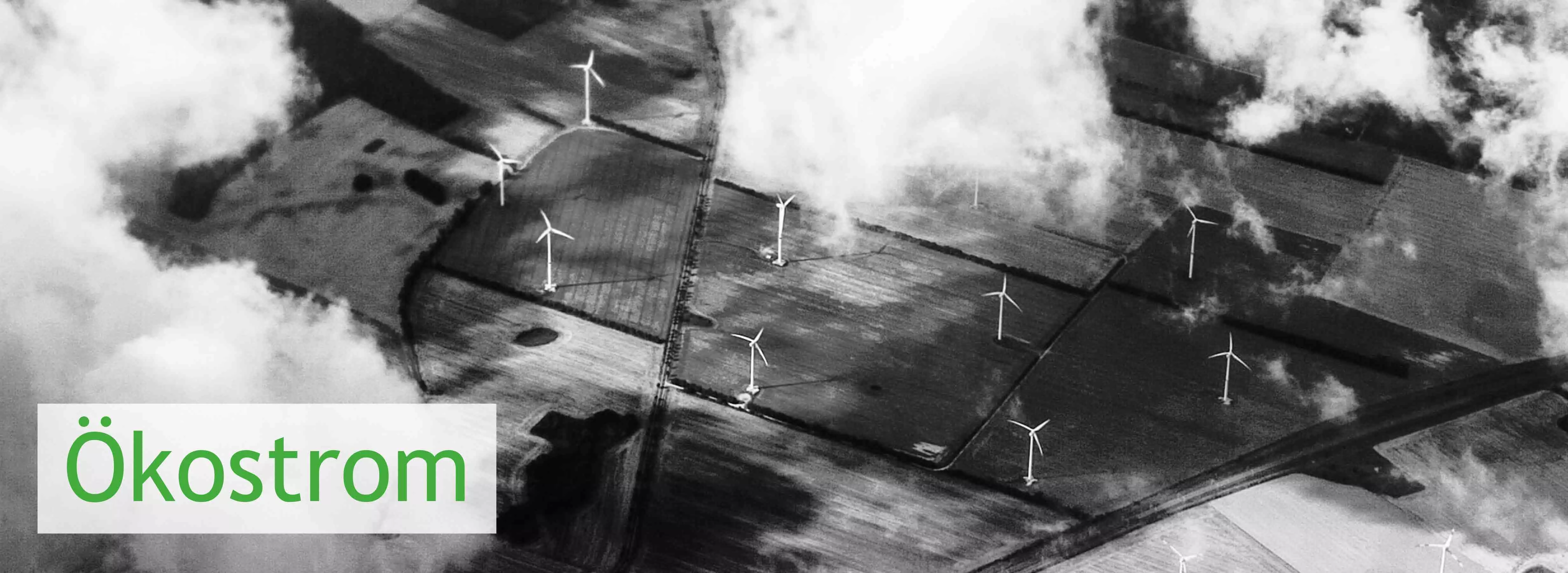 Luftaufnahme einiger Windräder auf Feldern unter einer zerrissenen Wolkendecke